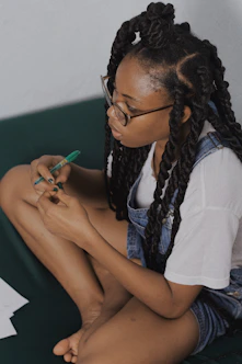 woman in white shirt holding green pen