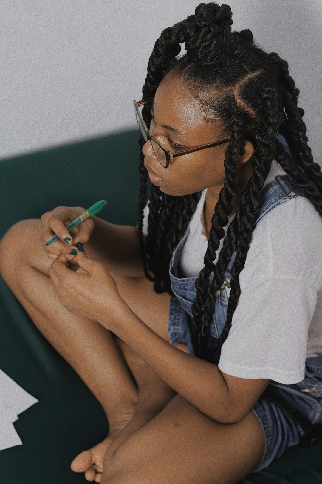 woman in white shirt holding green pen