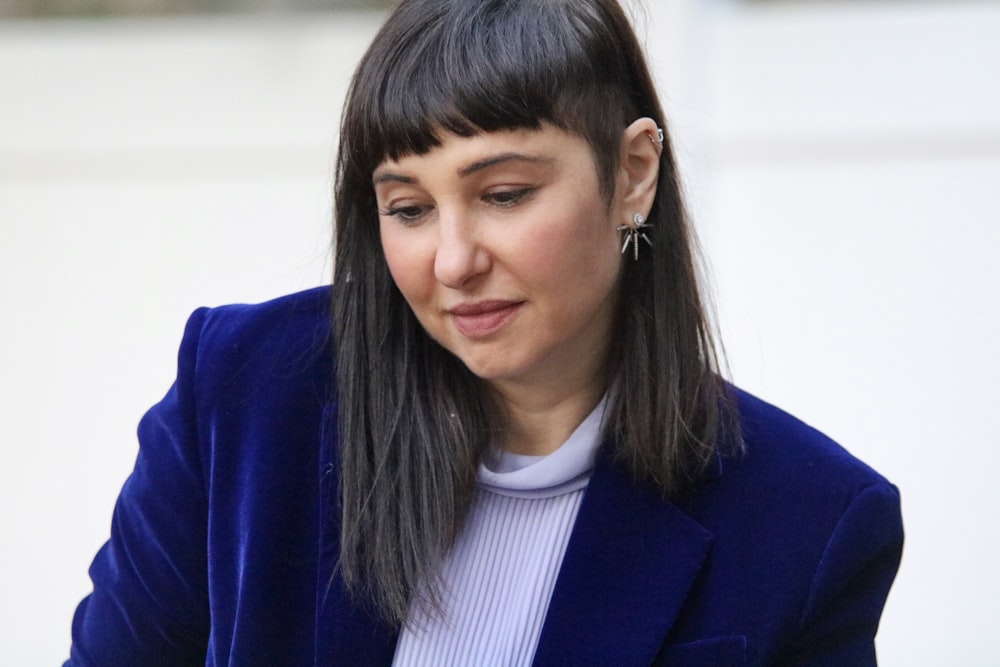 a woman in a blue jacket looking at her cell phone
