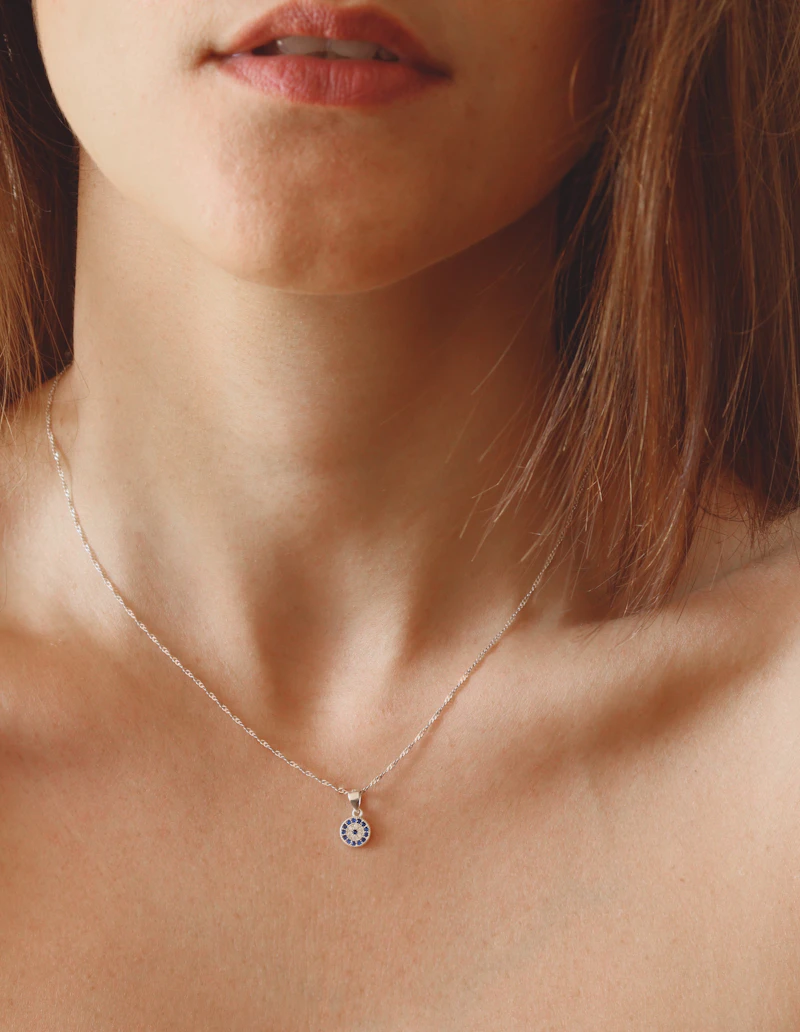 Adult woman wearing a fine diamond pendant on a delicate chain