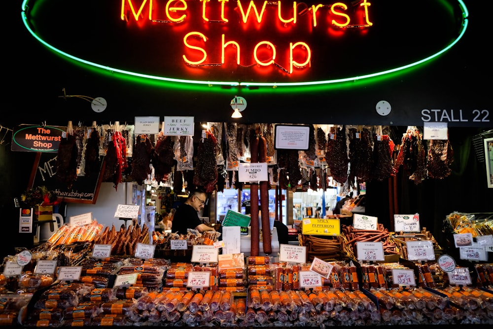 Una tienda con un letrero de neón que dice Mettwurst Shop