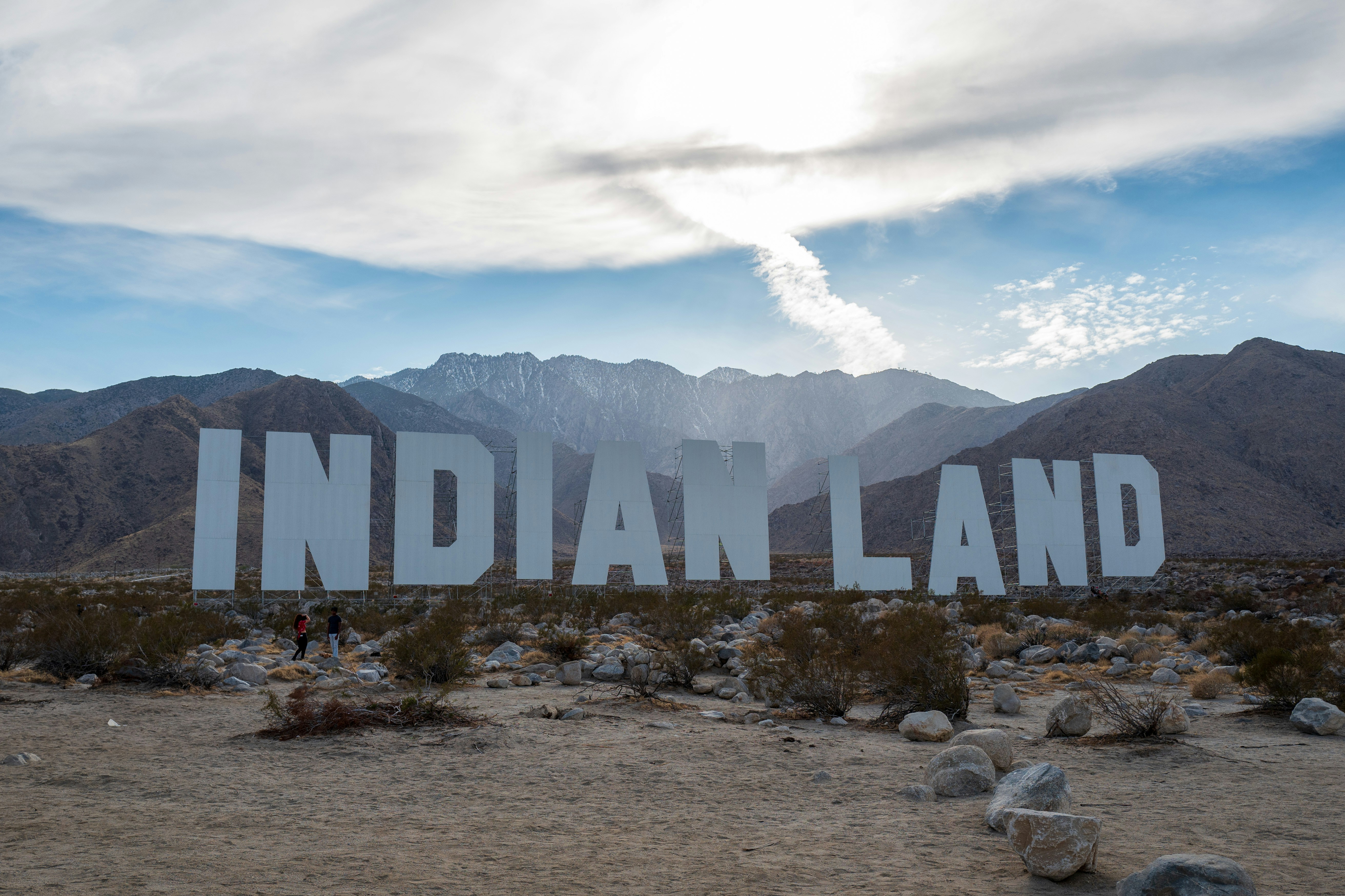 Rocas marrones y grises cerca de la montaña bajo nubes blancas durante el día