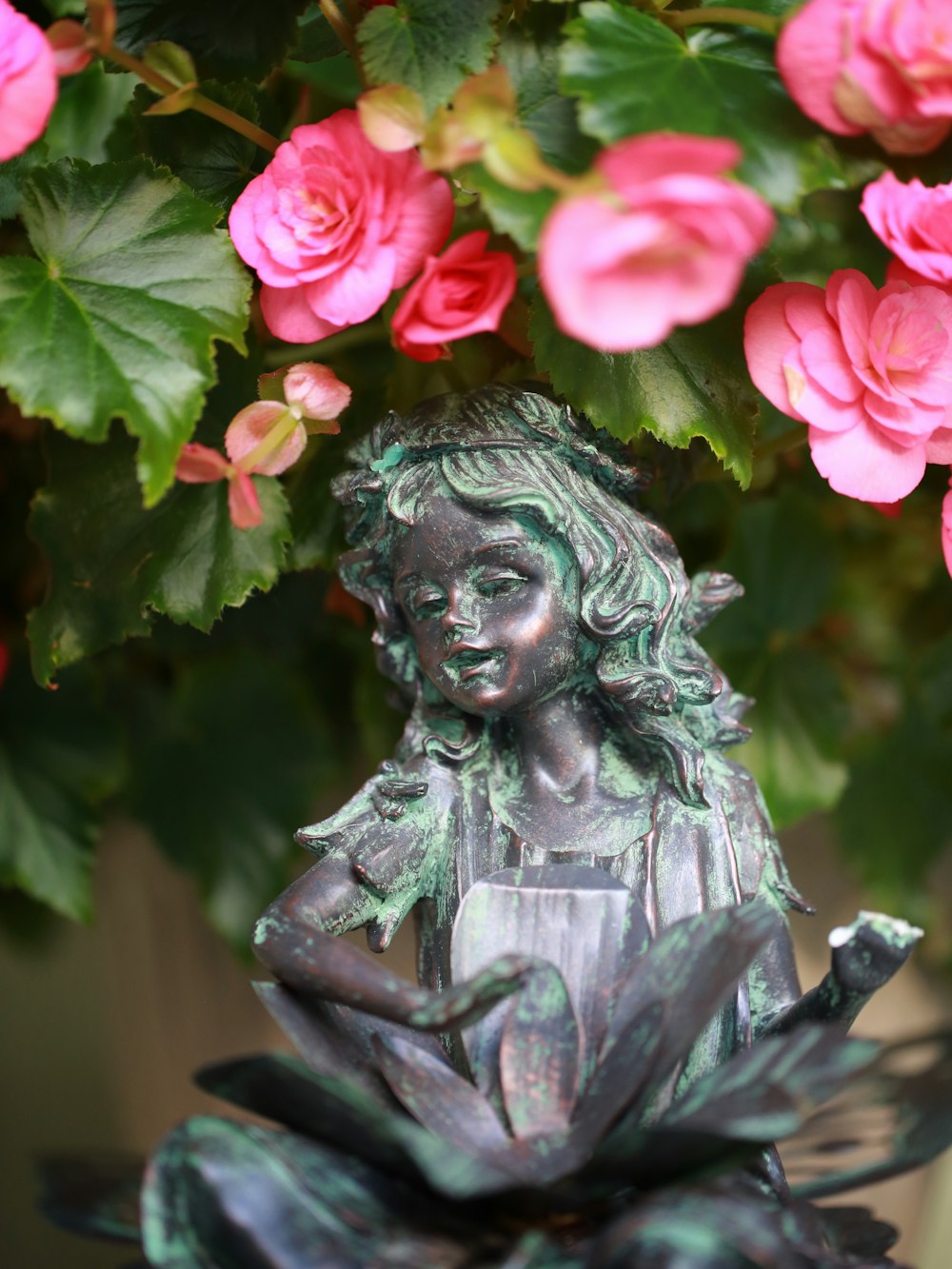 woman with pink rose on her head statue