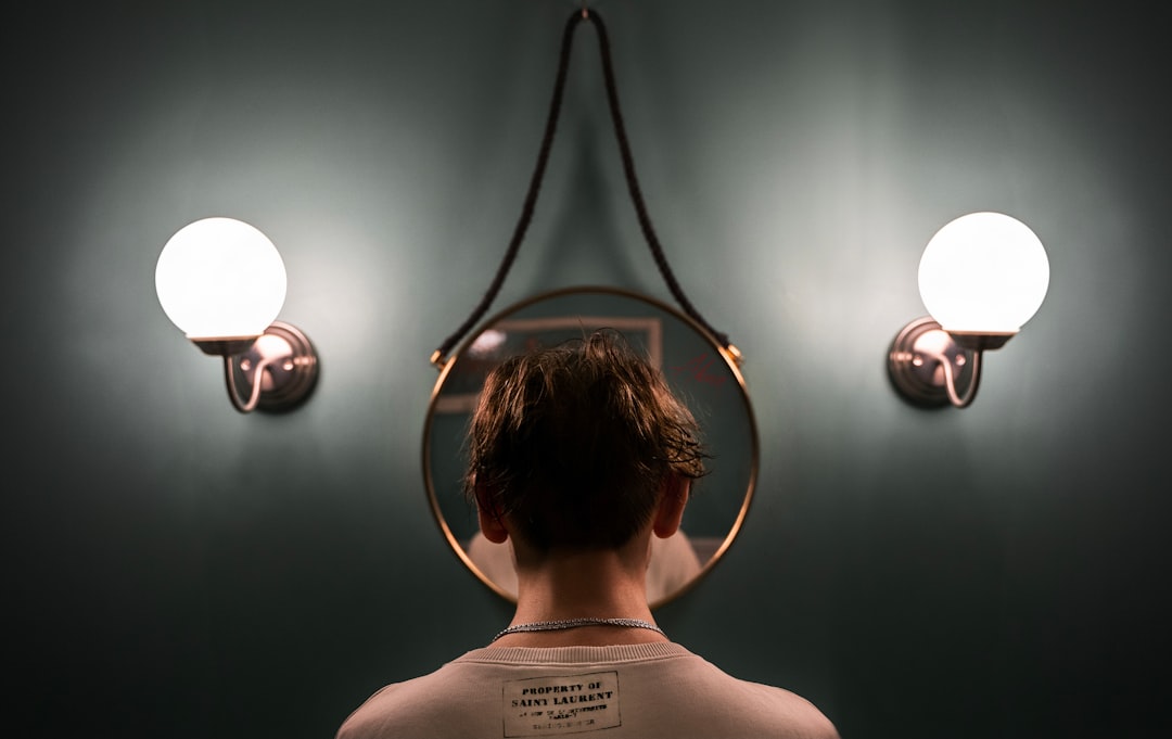 boy in white tank top standing in front of black and white wall lamp