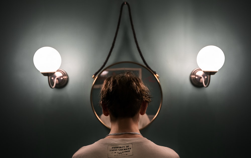 boy in white tank top standing in front of black and white wall lamp