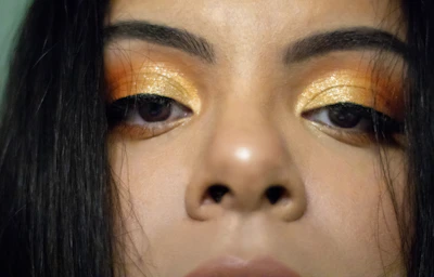 Close-up of elegant bridal eye makeup with shimmering gold tones and delicate eyeliner.