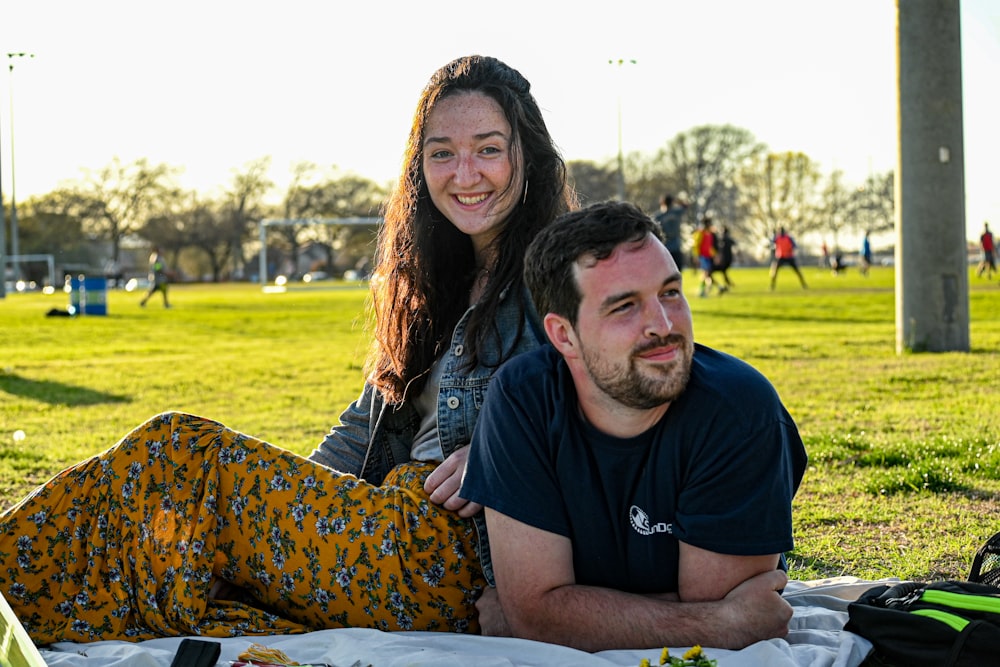 man in black crew neck t-shirt sitting beside woman in yellow and black leopard print