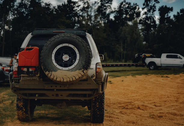 A rugged 4WD vehicle equipped for off-road towing, parked beside a scenic trail.