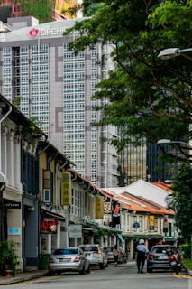 Exterior view of Tropicana 218 Macalister with a bustling city street and nearby food spots