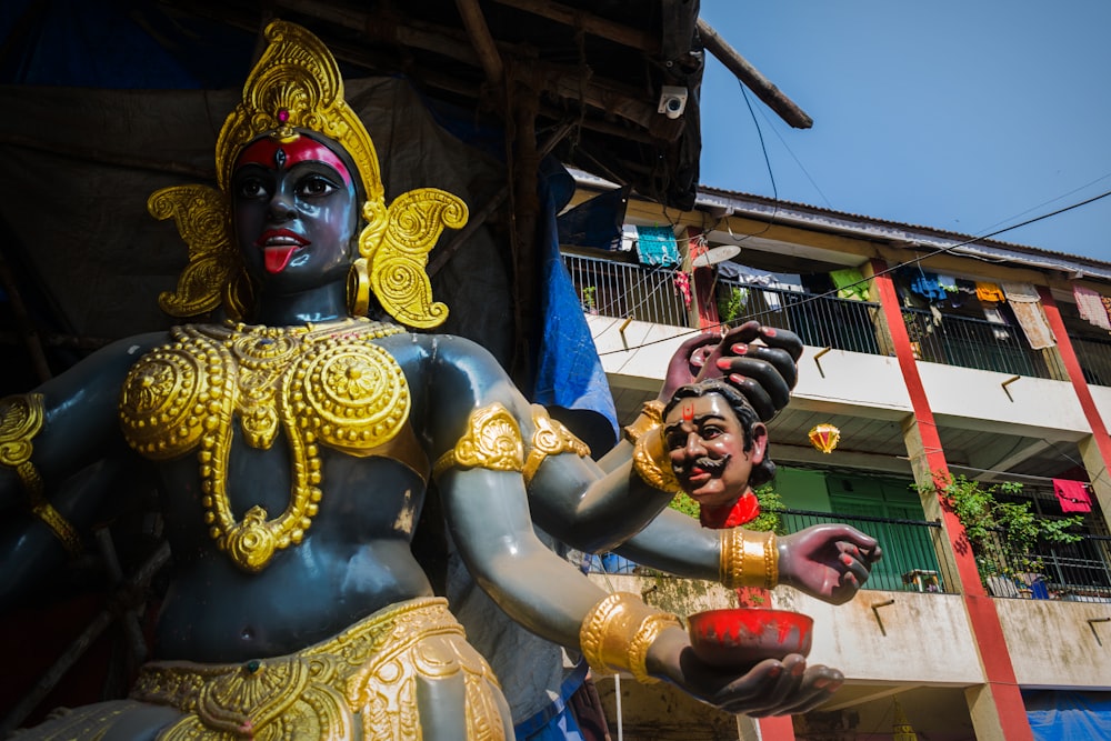 Statua della divinità indù in oro e rosso