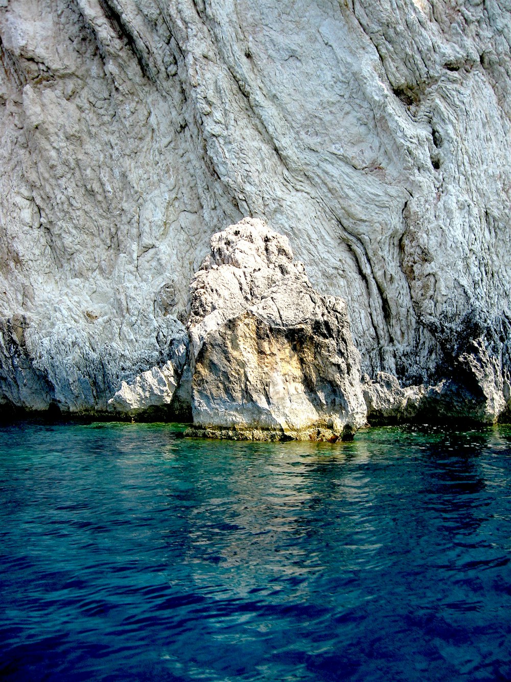 gray rock formation beside body of water during daytime