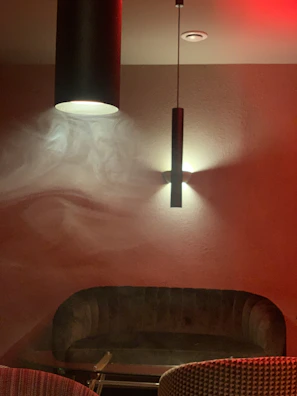 Elegant living space with black and smoky gradient walls accented by warm bronze lighting.