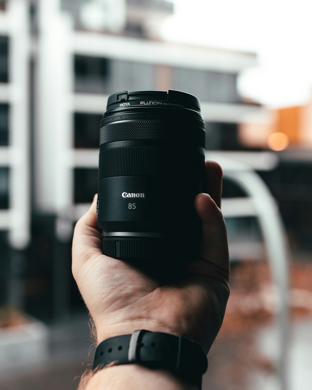 person holding black camera lens