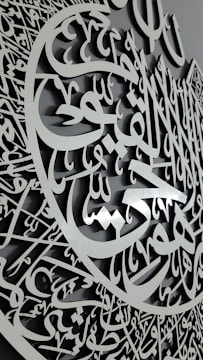 A delicate gold ring with traditional Arabic calligraphy.