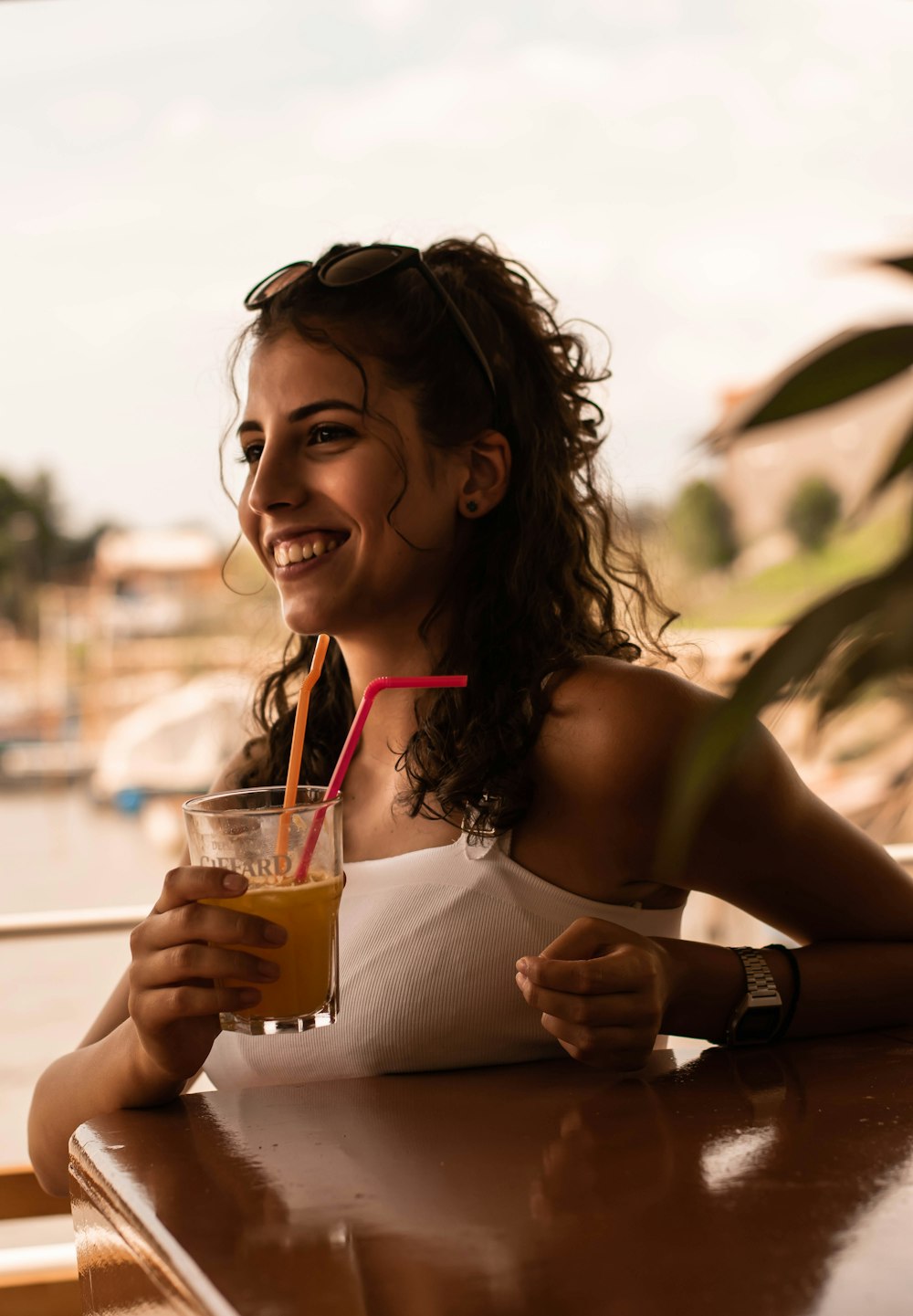 woman in white tank top holding clear drinking glass