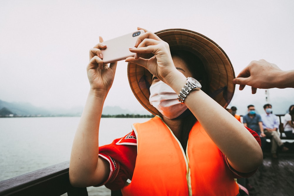 person in red shirt holding white smartphone