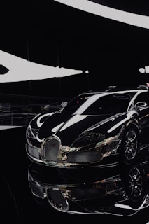 A sleek black sports car gleaming under showroom lights, highlighting its polished curves.