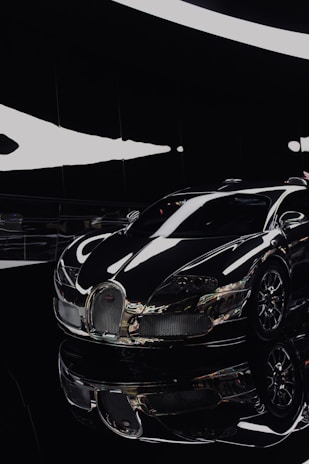 A sleek black sports car gleaming under showroom lights, highlighting its polished curves.