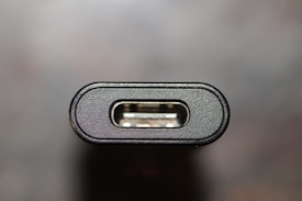 Close-up of a USB type-C port displaying its metallic interior with a black plastic outer casing against a blurred background.