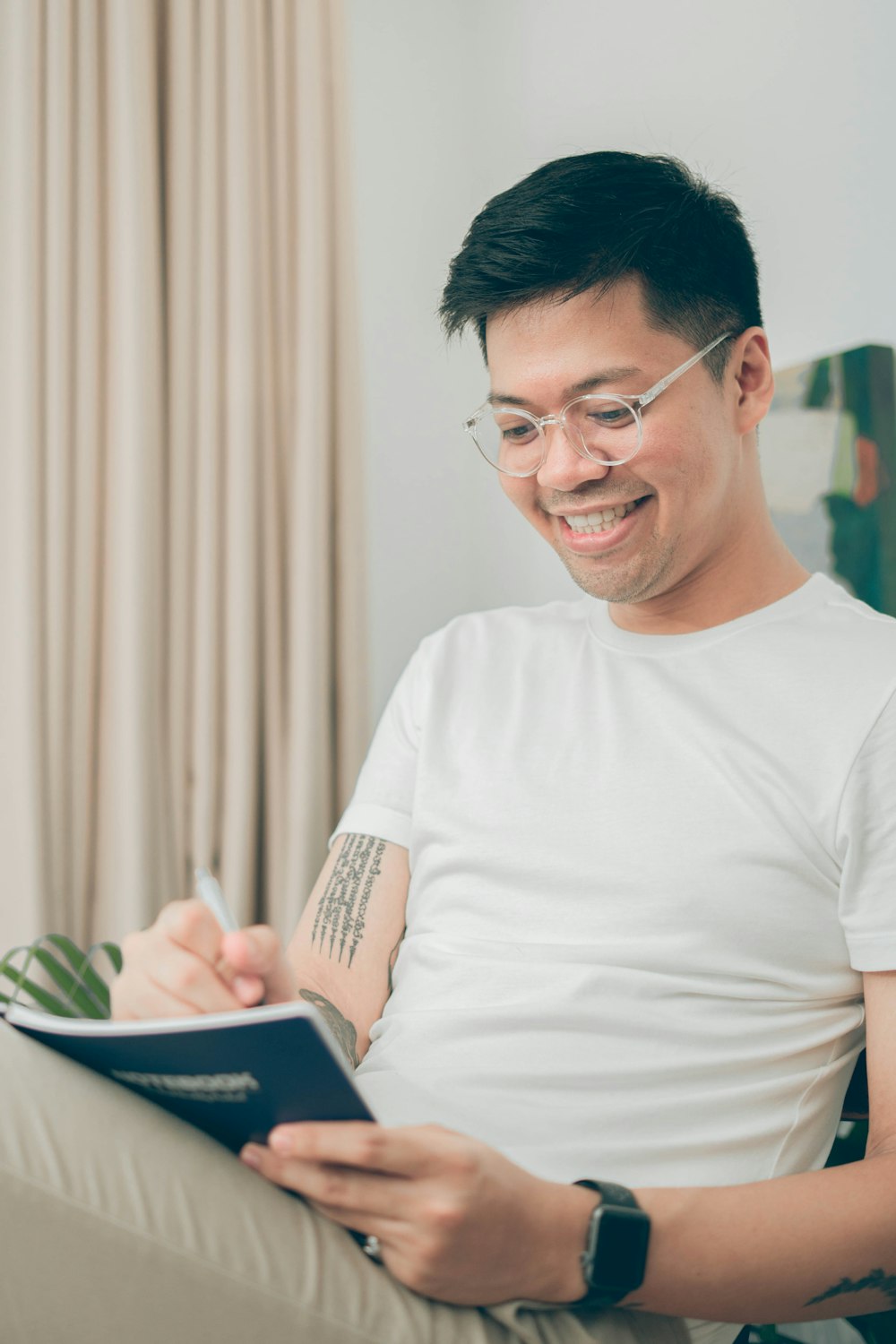 man in white crew neck t-shirt holding white ipad