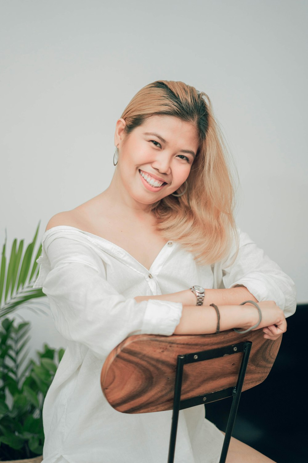 woman in white long sleeve shirt sitting on brown wooden chair