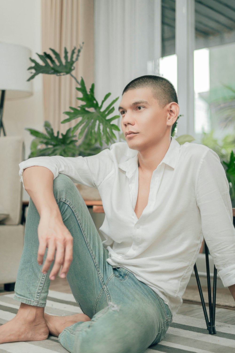 woman in white long sleeve shirt and gray denim jeans sitting on gray chair