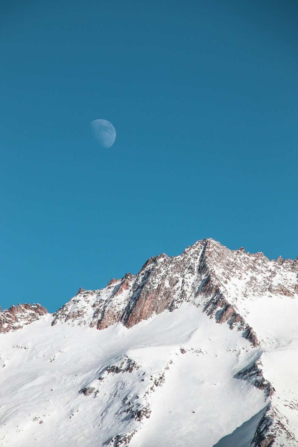 montagna coperta di neve sotto il cielo blu durante il giorno