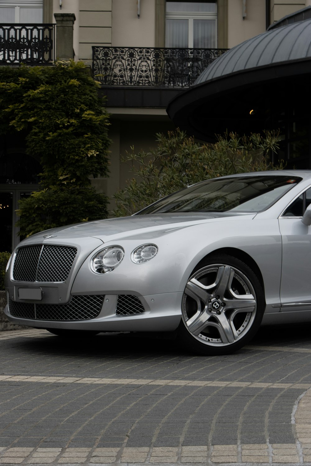 silver mercedes benz coupe parked near green trees during daytime