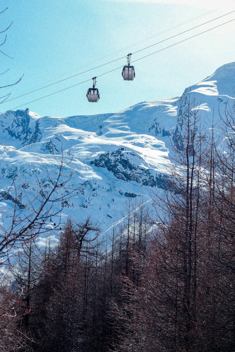 black cable car over snow covered mountain