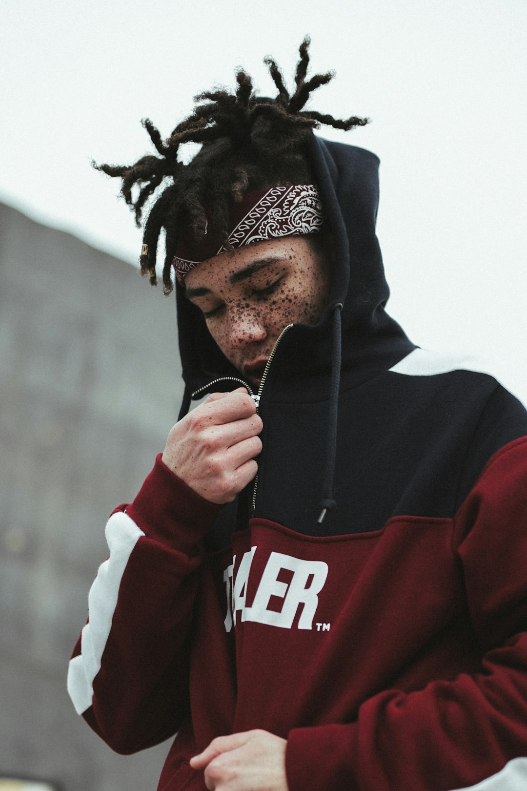 man in red and black hoodie smoking cigarette