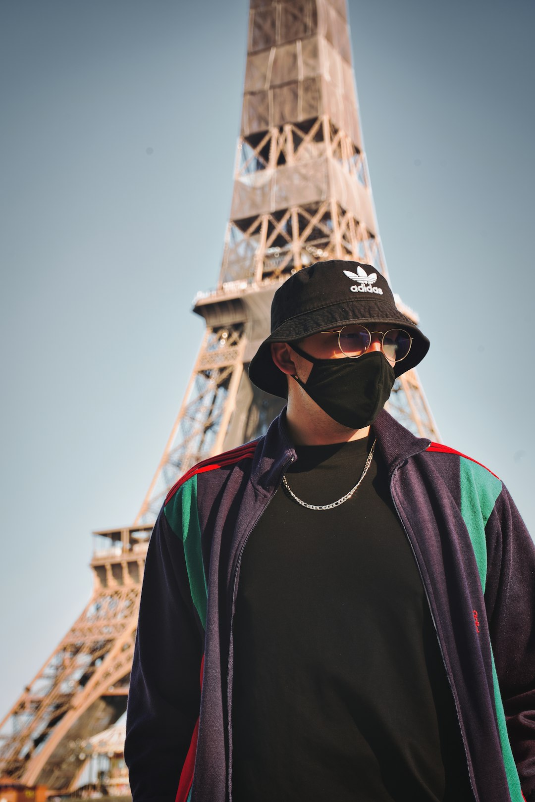 man in black and red zip up jacket wearing black fitted cap and black sunglasses