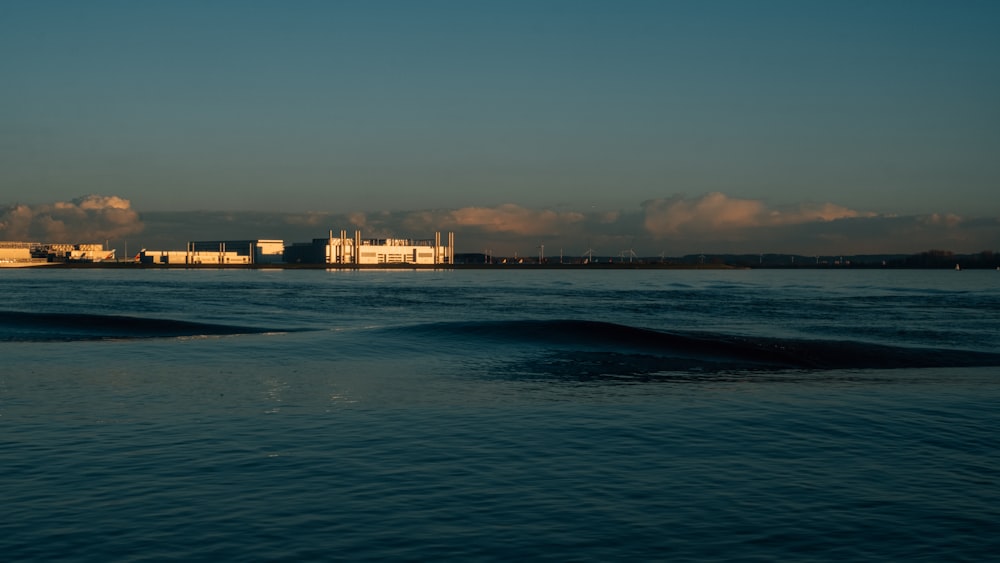 body of water near city buildings during sunset