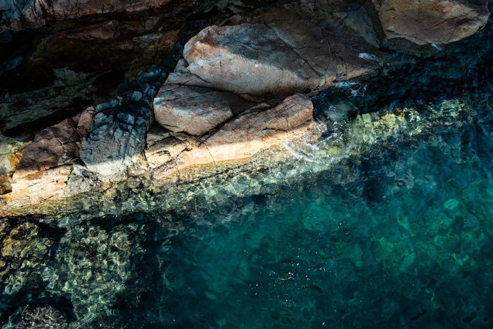 formação rochosa marrom no meio da água
