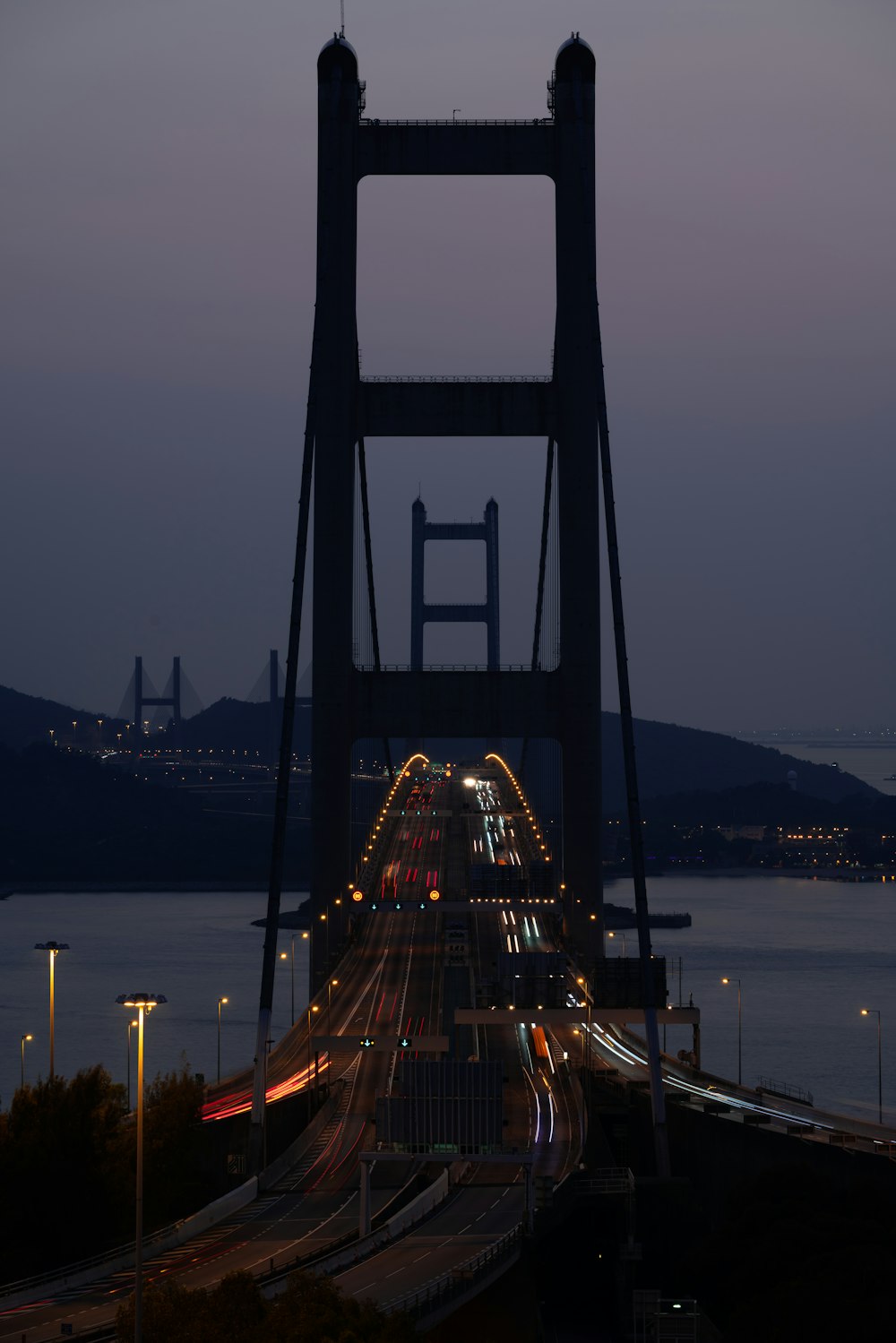 lighted bridge over body of water during night time