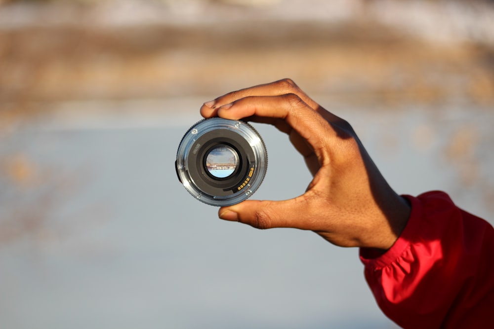 person holding black and silver camera lens