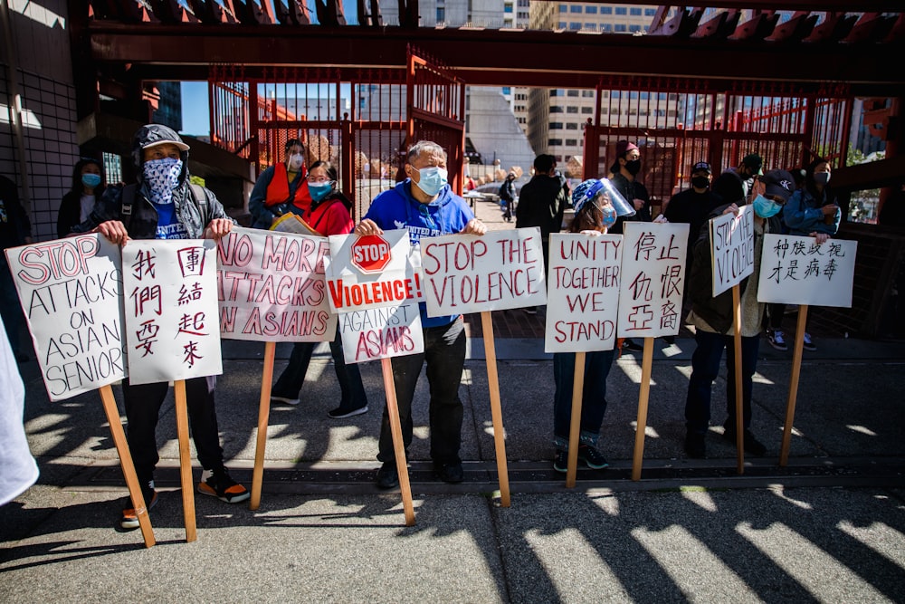 group of people holding white and red banner