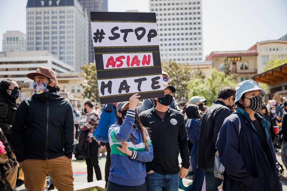 a group of people standing around each other holding signs