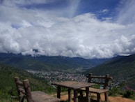 A rustic wooden table set with homemade lunch overlooking a lush valley.
