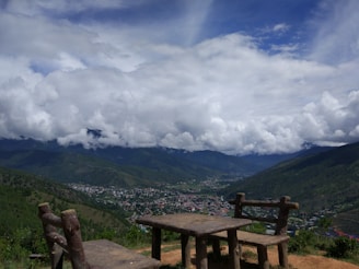 A rustic wooden table set with homemade lunch overlooking a lush valley.
