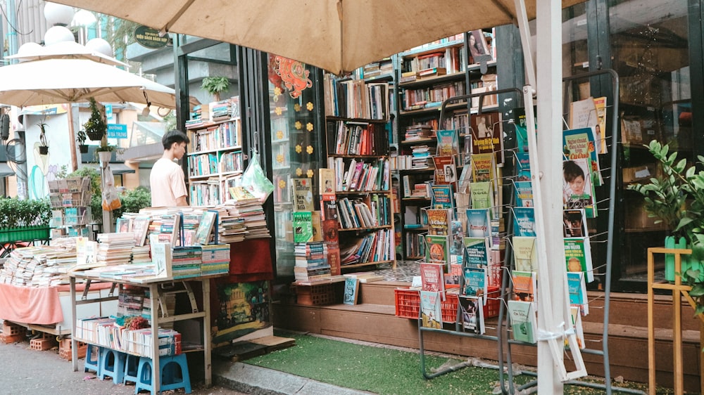 books on shelves beside store during daytime