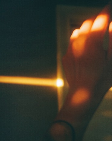 Golden hour light casting shadows over hands crafting with natural materials.