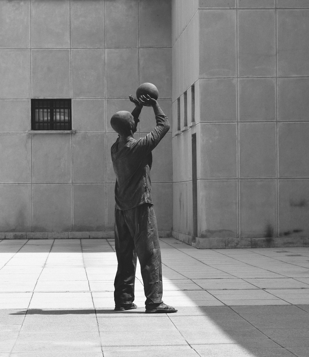 man in black jacket and pants standing on gray concrete floor