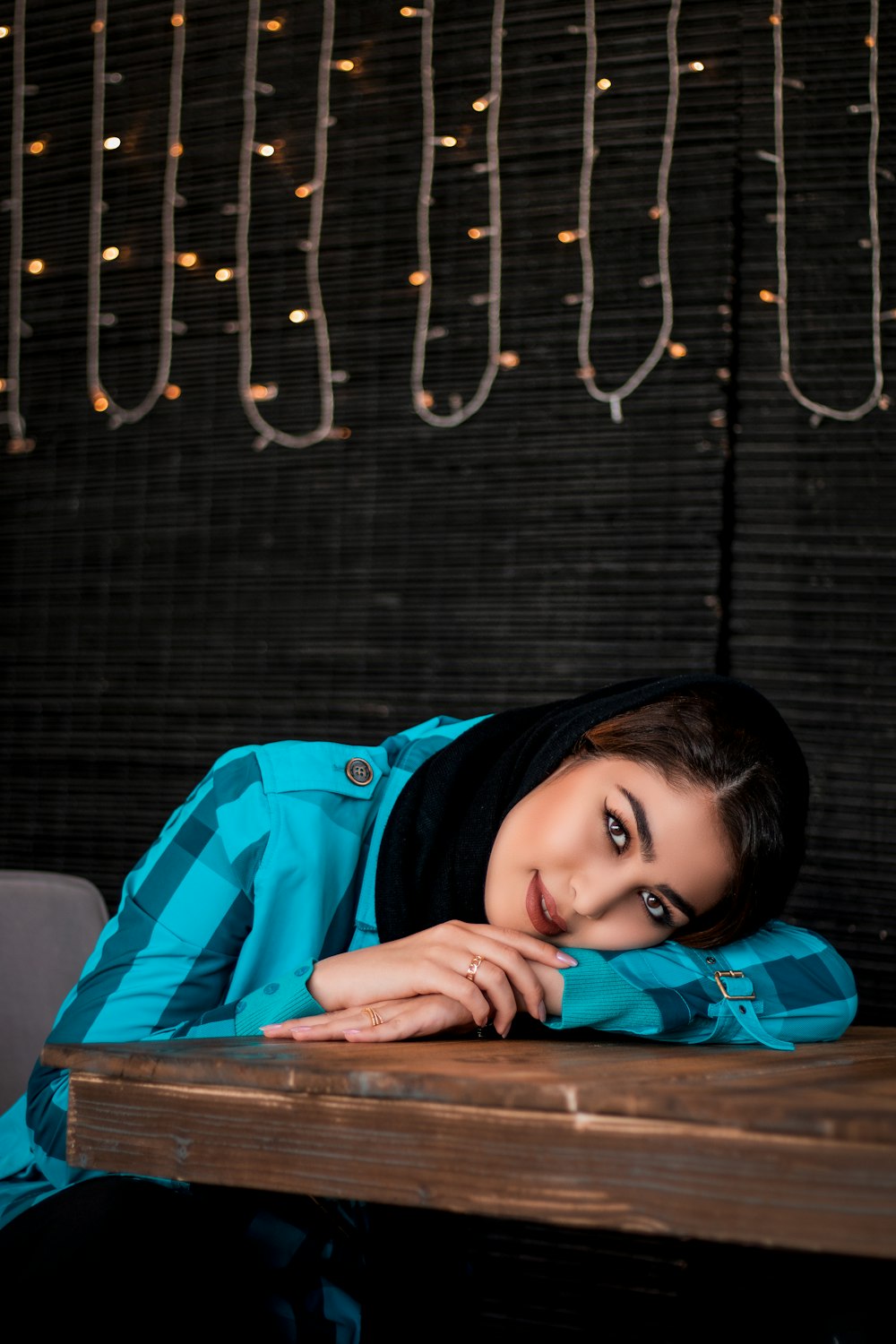 girl in blue jacket lying on blue bed
