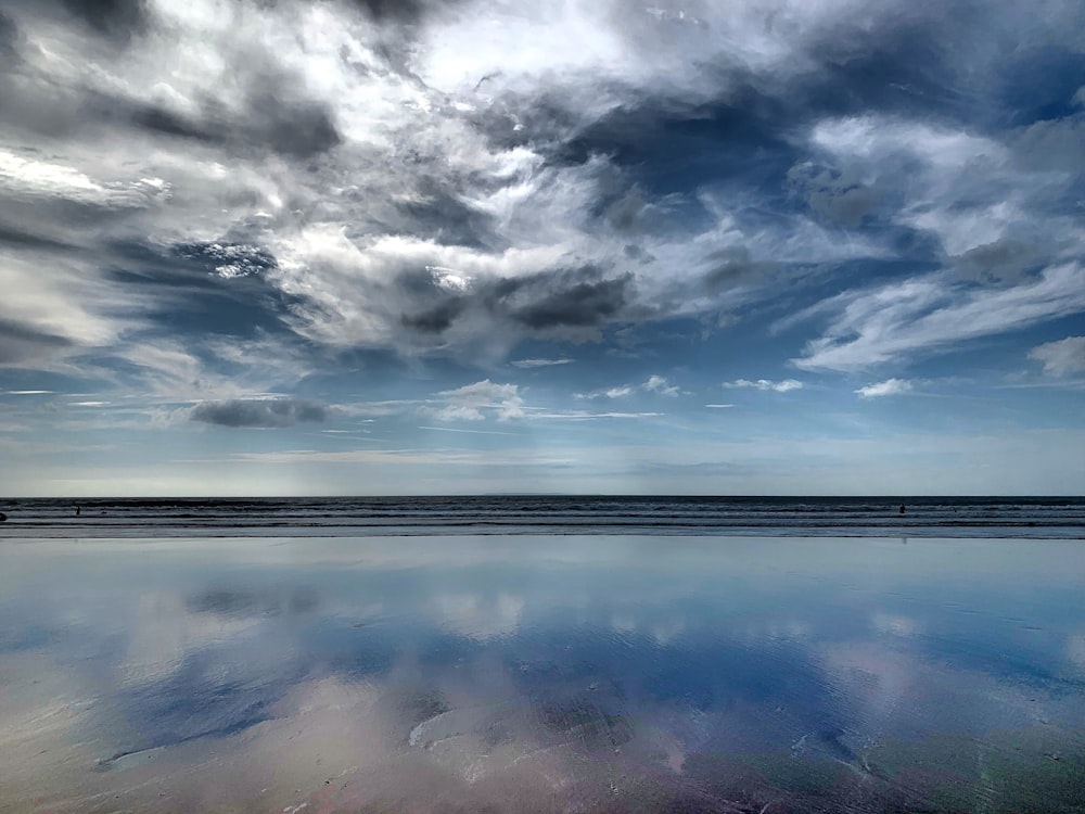 body of water under cloudy sky during daytime