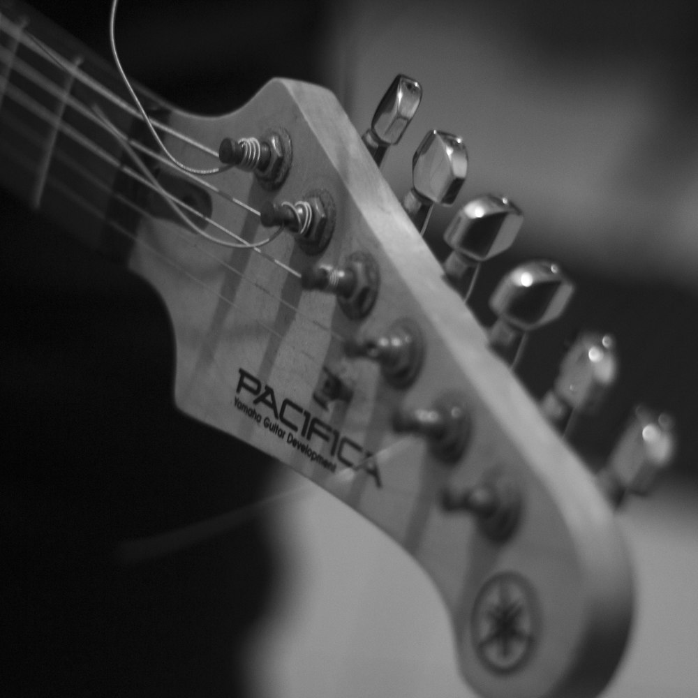 grayscale photo of guitar headstock