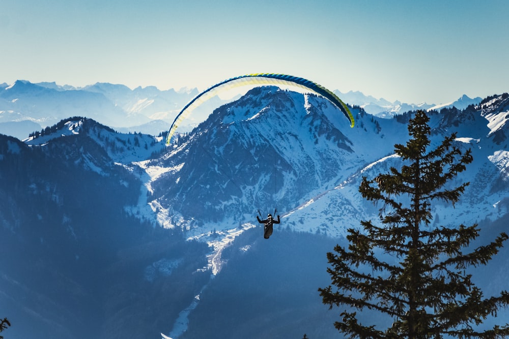 person riding on black cable car over snow covered mountain during daytime