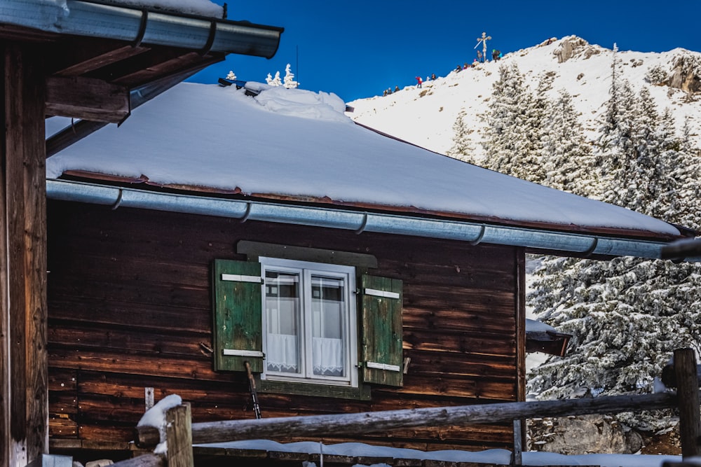 brown wooden house covered with snow during daytime