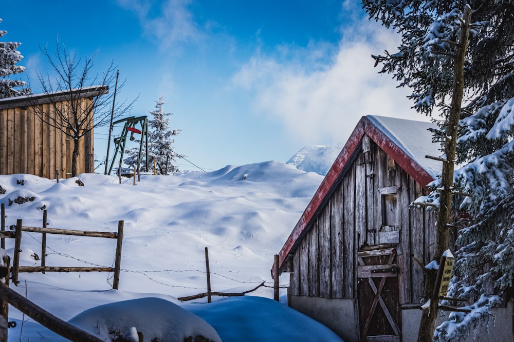 brown wooden house on snow covered ground during daytime