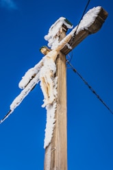 white snow on brown wooden post
