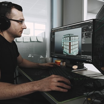 man in black tank top wearing black sunglasses using computer